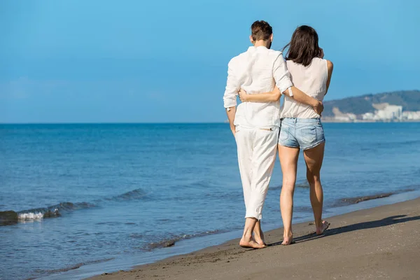 Young couple walking on beach smiling — Stock Photo, Image