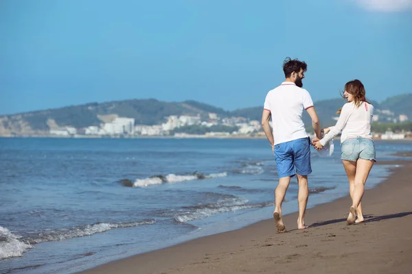 Jeune couple marchant sur la plage — Photo