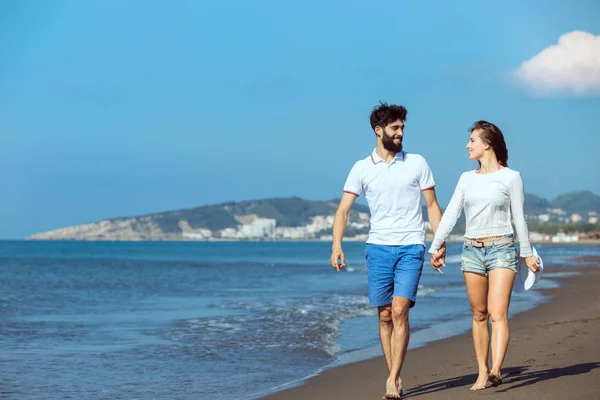 Young couple walking on beach Stock Picture