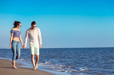 Mutlu ırklararası çift Sahilde yürüyüş.