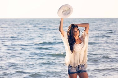 Genç bayan sahilde eğleniyor.