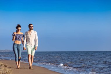 Mutlu ırklararası çift Sahilde yürüyüş.
