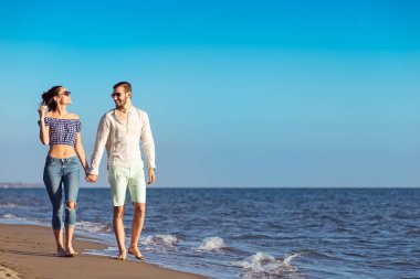 Mutlu ırklararası çift Sahilde yürüyüş.