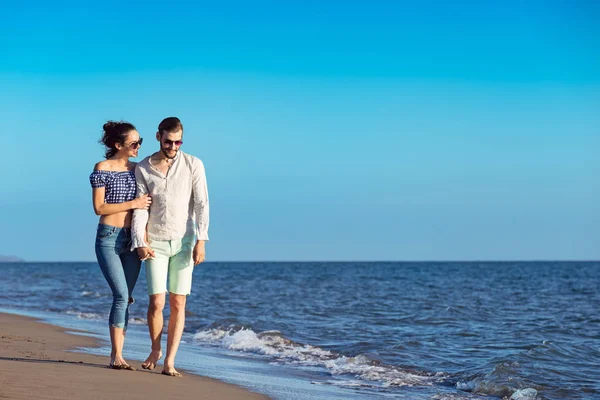 Happy interracial par promenader på stranden. — Stockfoto