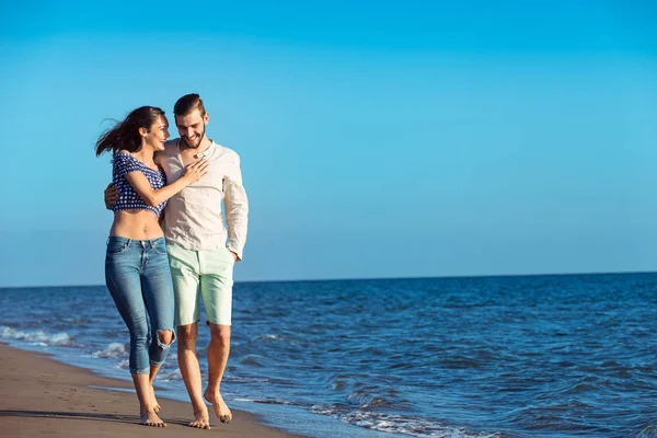 Feliz casal interracial andando na praia . — Fotografia de Stock