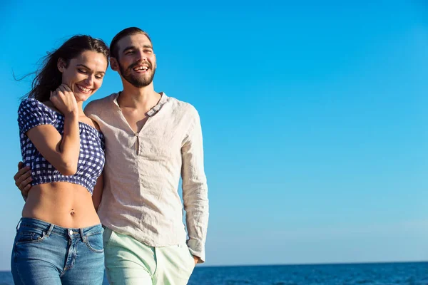 Feliz casal interracial andando na praia . — Fotografia de Stock