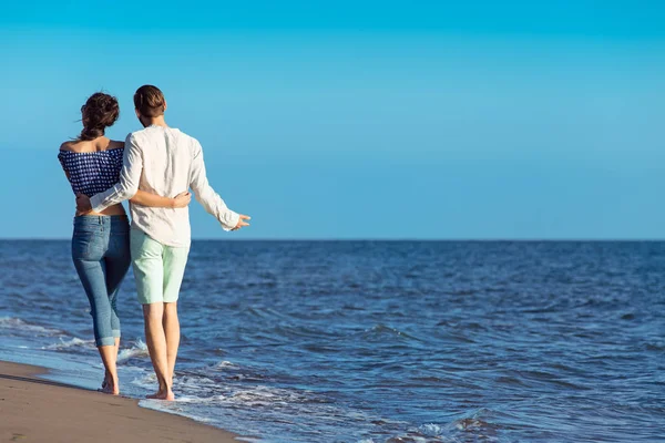 Šťastný pár interracial chůze na pláž. — Stock fotografie