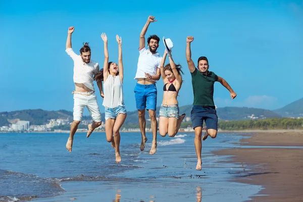 Gruppo di giovani che corrono sulla spiaggia — Foto Stock