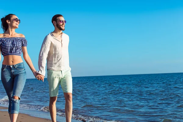 Feliz casal interracial andando na praia . — Fotografia de Stock