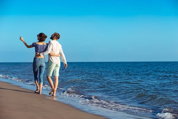 Feliz casal interracial andando na praia . — Fotografia de Stock