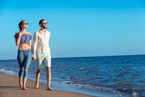 Feliz casal interracial andando na praia . — Fotografia de Stock