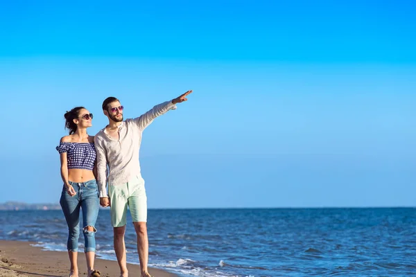 Feliz casal interracial andando na praia . — Fotografia de Stock