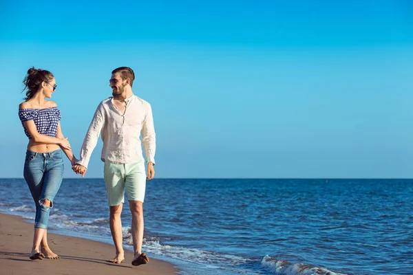 Šťastný pár interracial chůze na pláž. — Stock fotografie
