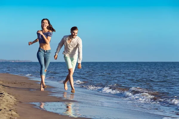 Casal feliz correndo na praia — Fotografia de Stock