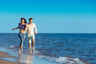 Kumsalda koşan mutlu çift