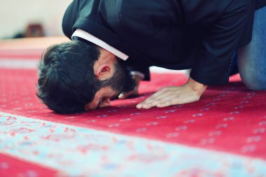 Müslüman adam camide namaz kılıyor.