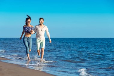 Kumsalda koşan mutlu çift