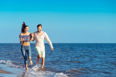 Kumsalda koşan mutlu çift