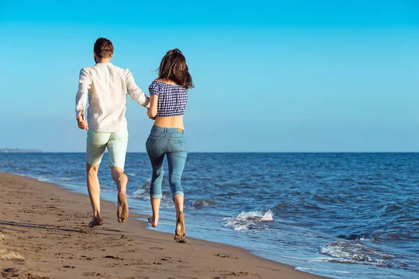 Casal feliz correndo na praia — Fotografia de Stock