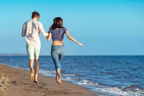 Gelukkig paar loopt op het strand — Stockfoto