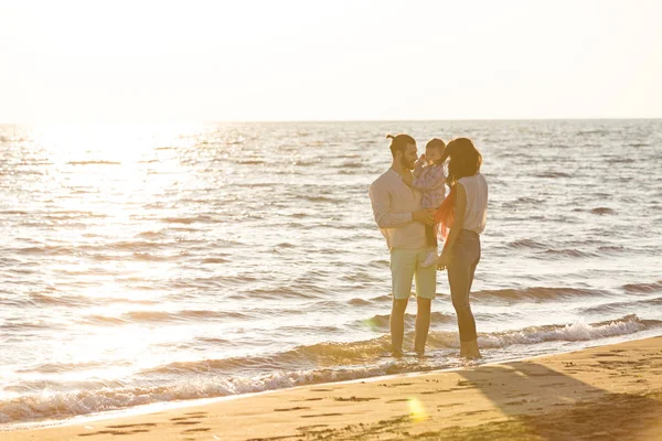 Ung familj ha kul på stranden — Stockfoto