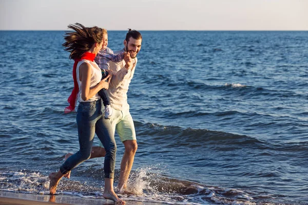 Jong gezin plezier hebben op strand — Stockfoto