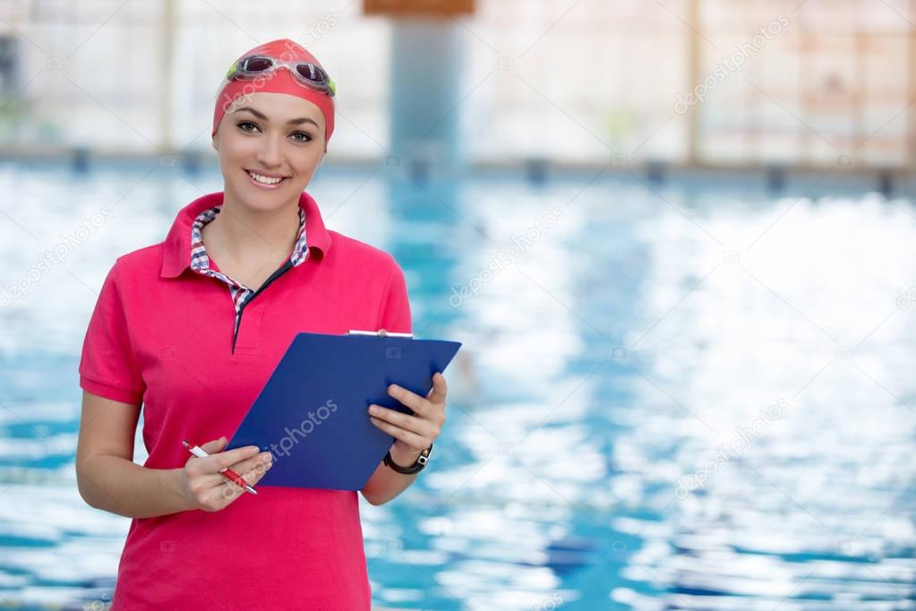 Fit female swimming trainer at the pool