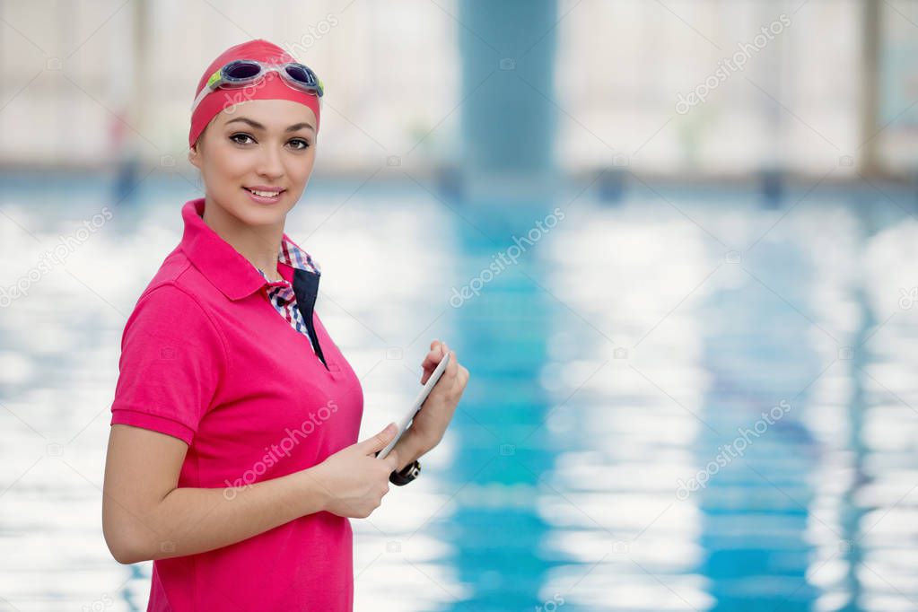 Fit female swimming trainer at the pool