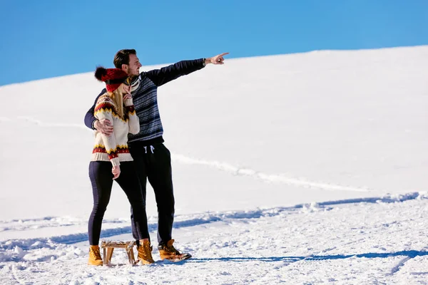 Homem e mulher com um trenó na neve — Fotografia de Stock