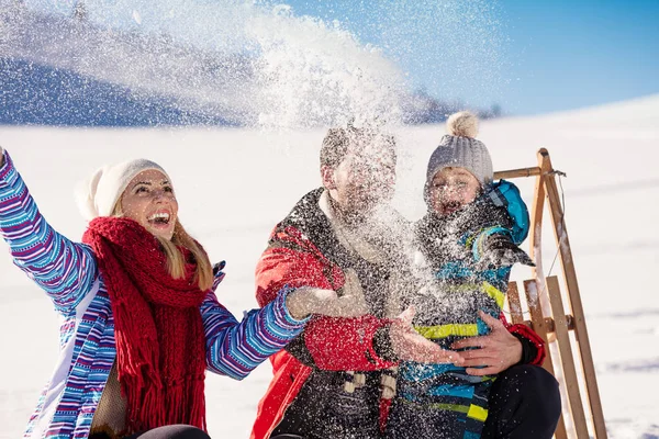 Família com criança no trenó no inverno — Fotografia de Stock