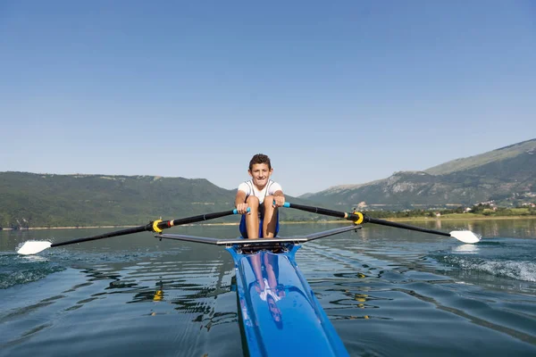 El joven deportista está remando en el kayak de carreras —  Fotos de Stock