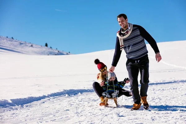 Family with child on sled in winter — Stock Photo, Image