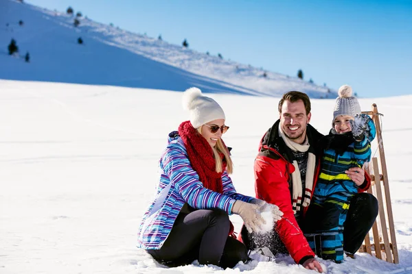 Família com criança no trenó no inverno — Fotografia de Stock