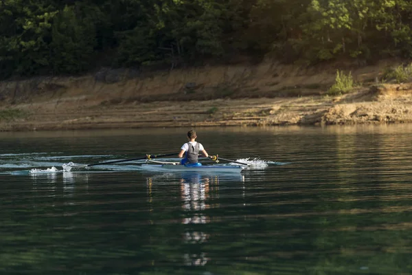 Joven solo scull remando en el lago — Foto de Stock