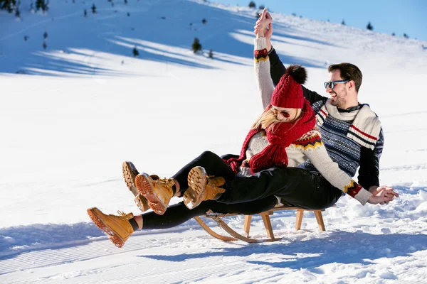 Casal jovem Sledding no inverno — Fotografia de Stock