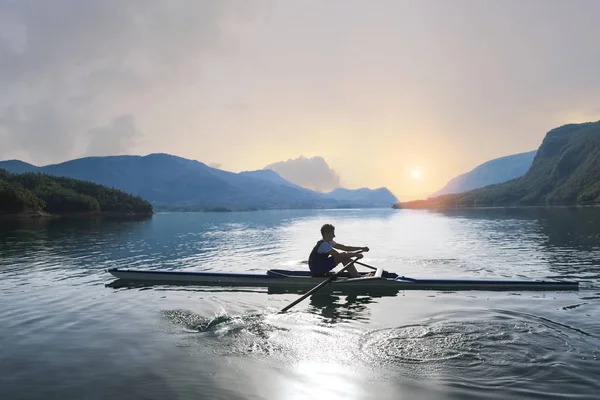 Joven solo scull remando en el lago — Foto de Stock