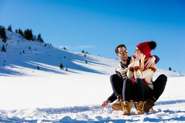 Pareja joven trineo en invierno — Foto de Stock