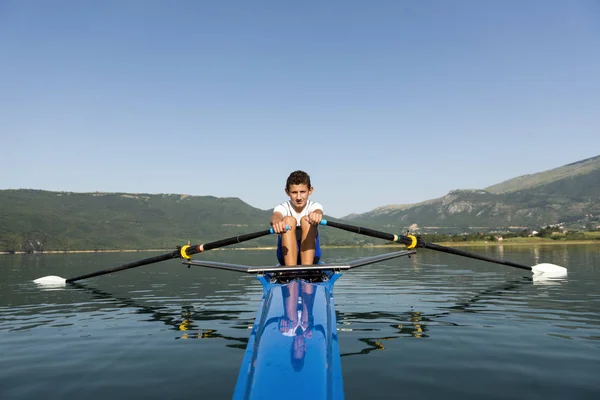 El joven deportista está remando en el kayak de carreras — Foto de Stock