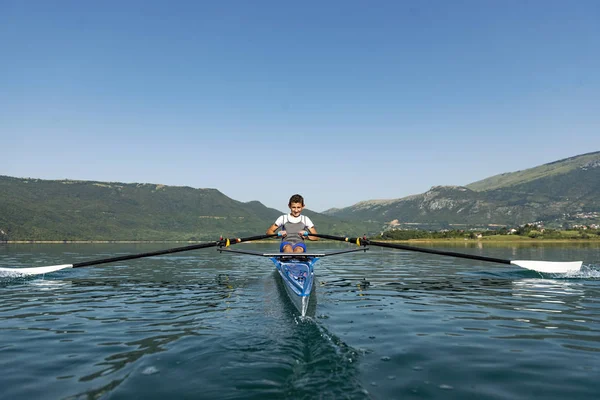 Der junge Sportler rudert auf dem Rennkajak — Stockfoto