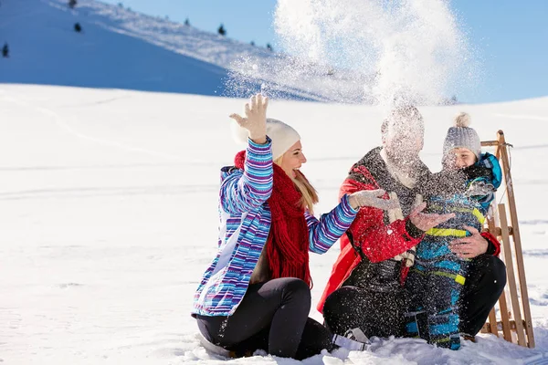 Gezin met kind op slee in de winter — Stockfoto