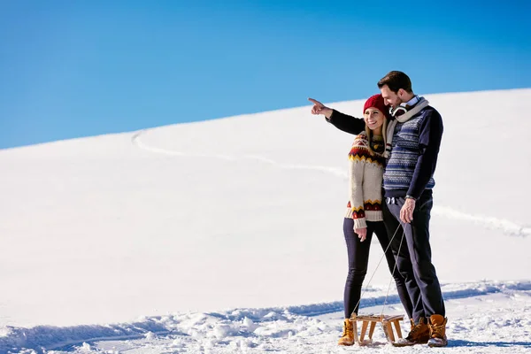 Мужчина и женщина с санями на снегу — стоковое фото