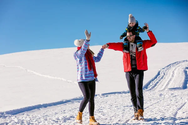 Familia divirtiéndose en un parque de invierno — Foto de Stock