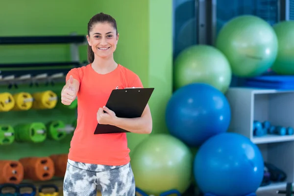 Sorridente feminino instrutor de fitness no ginásio — Fotografia de Stock