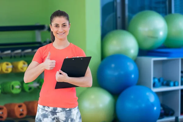 Sorridente feminino instrutor de fitness no ginásio — Fotografia de Stock