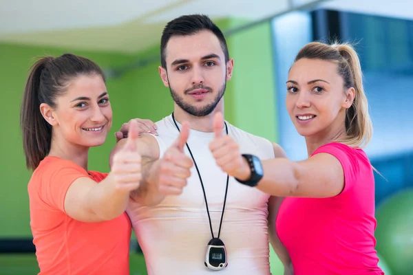 Aula de fitness mostrando polegares no ginásio — Fotografia de Stock