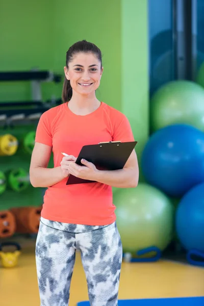 Sonriente instructora de fitness femenina en gimnasio —  Fotos de Stock