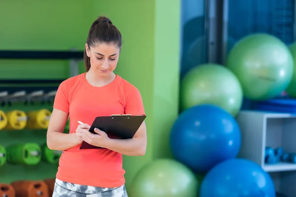 Sonriente instructora de fitness femenina en gimnasio —  Fotos de Stock