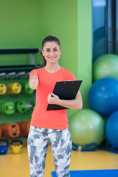 Sorridente feminino instrutor de fitness no ginásio — Fotografia de Stock