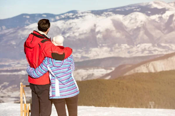 Loving couple at snowed mountain range — Stock Photo, Image