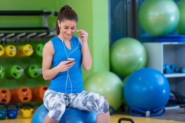 spor salonunda Smartphone kullanan kadın
